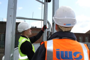 Two IWS M&E employees with high vis and hard hats
